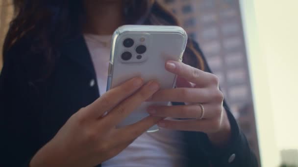 Las manos de una mujer desconocida sosteniendo un teléfono inteligente moderno de cerca. Chica utilizar el teléfono al aire libre — Vídeos de Stock