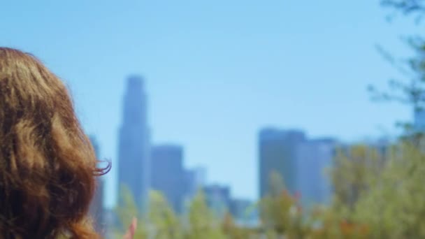 Невідома дівчина, що показує знак LA пальцями крупним планом. Жінка стоїть в літньому парку . — стокове відео
