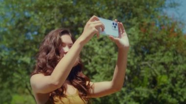 Kadın turist video manzarası hazırlıyor. Asyalı kız park manzarası çekiyor.