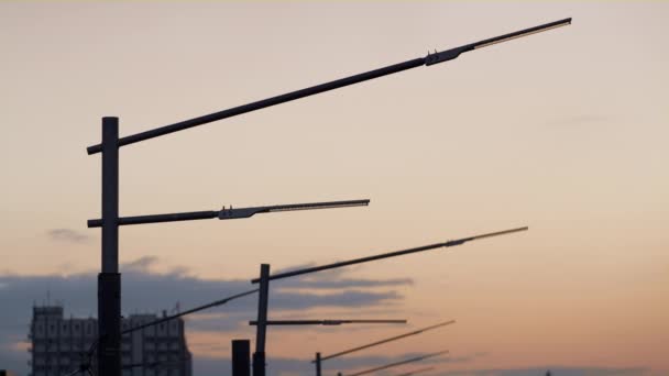 Primer plano potentes farolas siluetas drone disparo. Postes oscuros de metal. — Vídeos de Stock