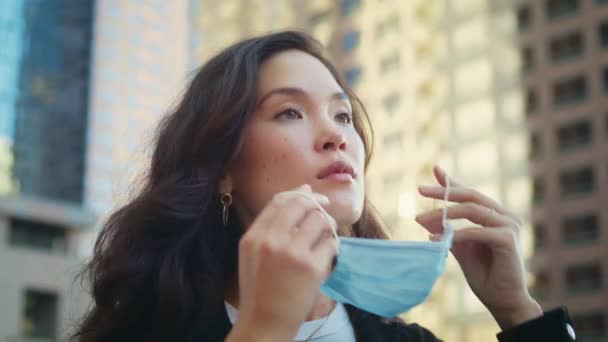 Vrouw met medisch masker buiten close-up. Aziatische meisje zorg gezondheid in pandemie. — Stockvideo