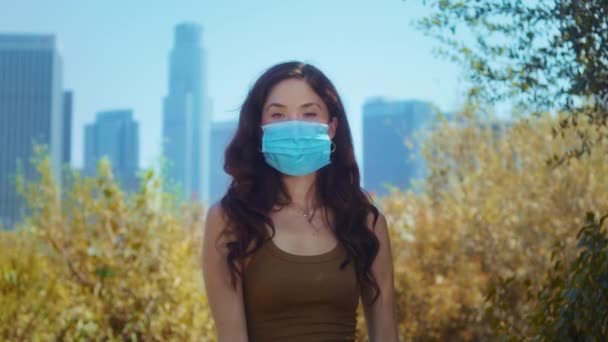 Asian model in mask looking camera in park closeup. Brunette care of health. — Stock Video