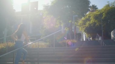 Yukarıdaki uzun saçlı kadın fotoğraf çekiyor. Asyalı kız merdiven boşluğunda koşar, selfie çeker.