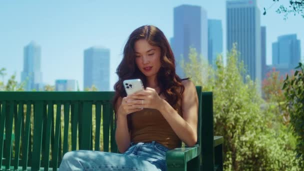 Numer telefonu turystki siedzi na ławce. Azji dziewczyna zadzwoń telefon na zewnątrz — Wideo stockowe