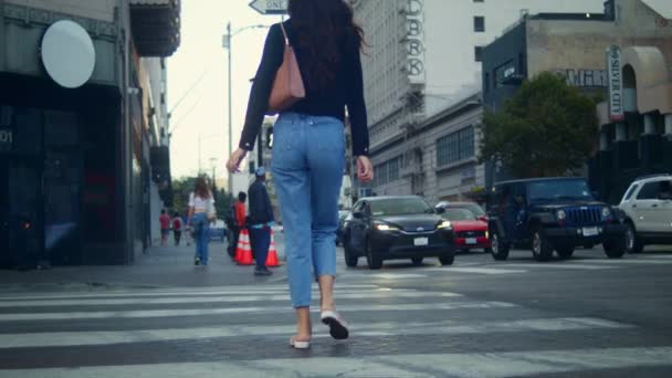 Nierozpoznana kobieta chodząca po skrzyżowaniu dużego miasta. Nieznana dziewczyna przekraczania drogi. — Wideo stockowe