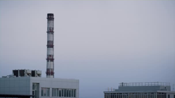 Fabrica turn țeavă în zona industrială oraș violet seara timp drone împușcat. — Videoclip de stoc