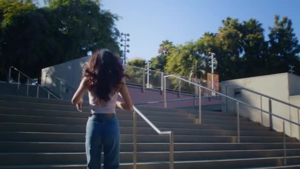 Веселий брюнетка біжить нагору. Азійська дівчина піднімається сходами, щоб сфотографувати. — стокове відео