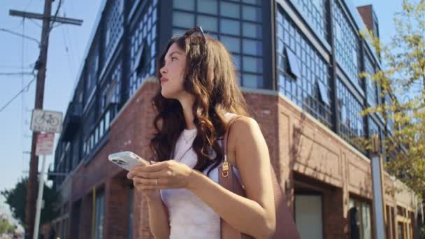 Seriöse Dame sucht Standort mit Telefon auf der Straße. Asiatische Mädchen stehen am Scheideweg. — Stockvideo