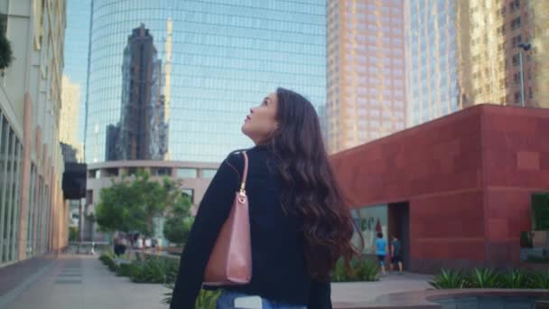 Brunette vrouw die het stadsgezicht verkent. Aziatisch meisje op zoek op hoge gebouwen. — Stockvideo