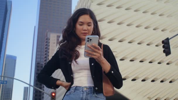 Belle fille utilisant un smartphone dans la rue. Femme asiatique tapant sur le téléphone gros plan. — Video
