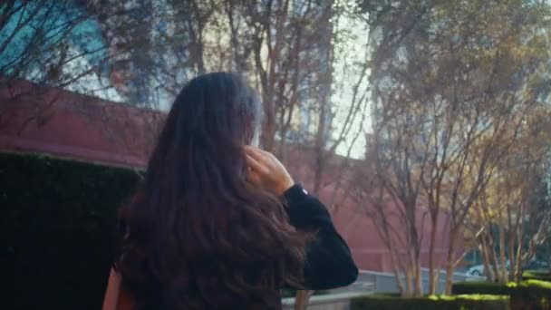 Brünette Dame drehen sich um und gehen megapolis. Asiatische Mädchen auf Sonnenlicht Rückseite — Stockvideo