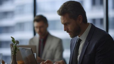 Odaklanmış profesyonel iş bilgisayarı ofis kafesinde video görüşmesi yapıyor..