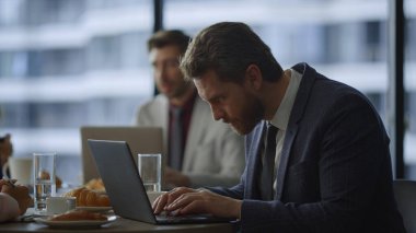 Birlikte çalışan kafede dizüstü bilgisayar keayboard 'u yazan odaklanmış serbest çalışan bir işçi..