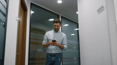 Gülümseyen müdür ofisten tek başına geçiyor iş merkezindeki cep telefonunu arıyor..