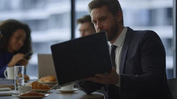 Gerente ocupado mostrando computador portátil para colega de negócios em restaurante café. — Fotografia de Stock