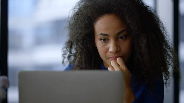 Fókuszált afro-amerikai üzletasszony keres laptop internet otthoni irodában. — Stock Fotó