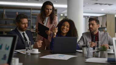 İş dünyası, ofis binasında dizüstü bilgisayarı araştıran fikirleri paylaşıyor..