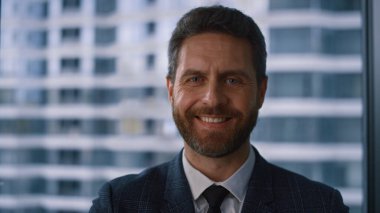 Şirket yöneticisi gülümseyen kamera görünümlü ofis şirketinde poz veriyor.