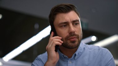 Ciddi iş adamı telefon aygıtı şirkette şirket bilgilerini tartışıyor.