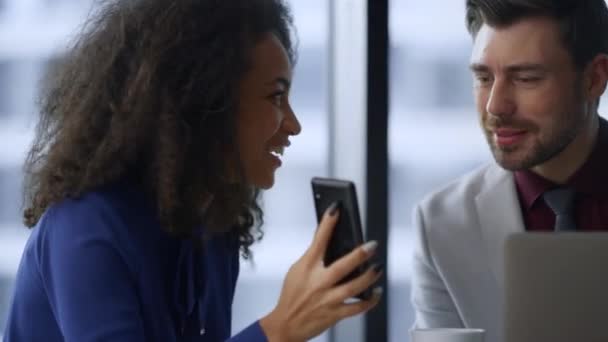 Happy businesswoman pokazuje telefon dzieląc się dobrą wiadomością z kolegą w biurze — Wideo stockowe