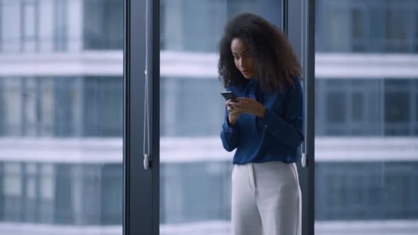 Emocionada mujer gerente afroamericana celebrando buenas noticias por teléfono en la oficina. — Vídeos de Stock
