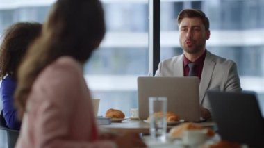 İş arkadaşları ofisteki dizüstü bilgisayarda çalışan kafe hakkında konuşuyor..