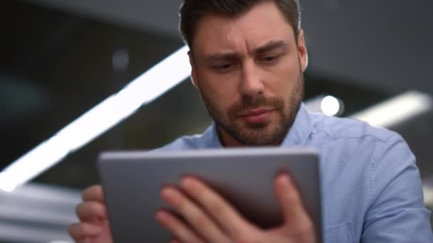 Bello uomo d'affari che lavora tablet alla ricerca di software aziendale in ufficio. — Video Stock