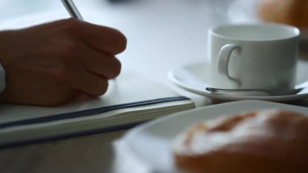 Donna mano scrittura blocco note seduta caffè lavoro note di scartoffie nel ristorante. — Video Stock