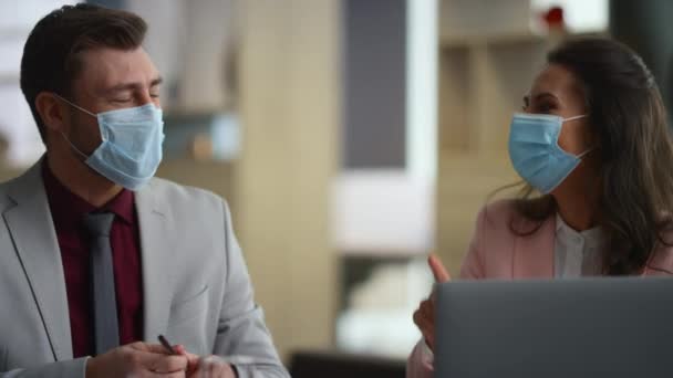 Para biznesmenów rozmawia o ochronie twarzy przed zużyciem w biurze finansowym. — Wideo stockowe