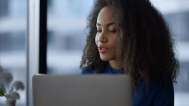 Afrikalı Amerikalı CEO kadın laptopta çalışırken sabah kahvesini ofiste içmeyi seviyor..
