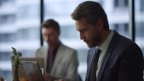 Focused homme professionnel portable de travail faisant appel à la vidéo en ligne dans le café de bureau. — Video