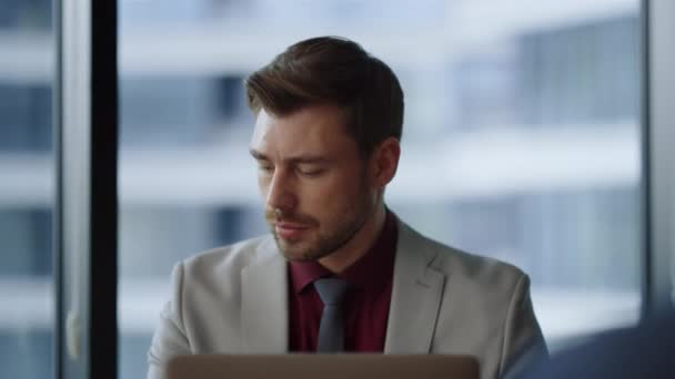 Сфокусированный мужчина генеральный директор работает с помощью компьютера глядя экран ноутбука в корпоративном офисе — стоковое видео