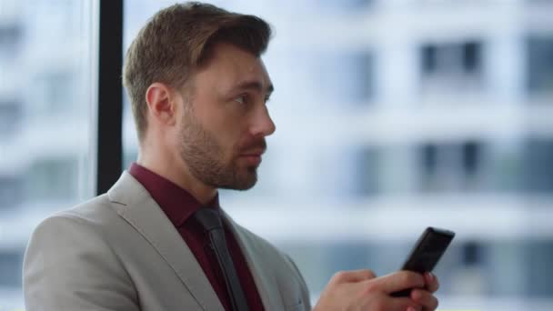 Hombre de negocios enfocado escribiendo teléfono navegar por Internet en la oficina del edificio corporativo. — Vídeos de Stock