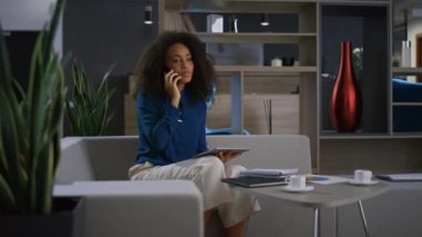 Afrikalı Amerikalı meşgul bir kadın cep telefonundan konuşuyor..