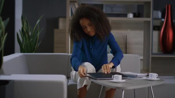 Occupato donna africana parlando telefono cellulare computer portatile di lavoro in ufficio remoto — Video Stock