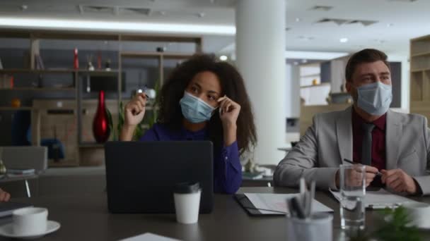 Команда бизнесменов в масках обсуждает корпоративную стратегию пандемии коронавируса. — стоковое видео