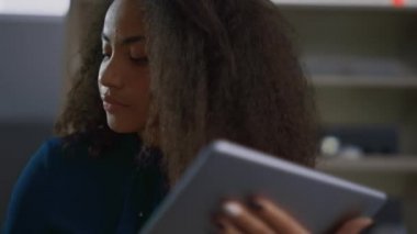Tablette çalışan Afrikalı Amerikalı CEO kadın. Girişimci ofiste telefonla konuşuyor..