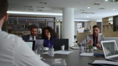 Çok ırklı çalışma arkadaşları ofiste beyin fırtınası fikirleri üzerinde birlikte çalışıyorlar.