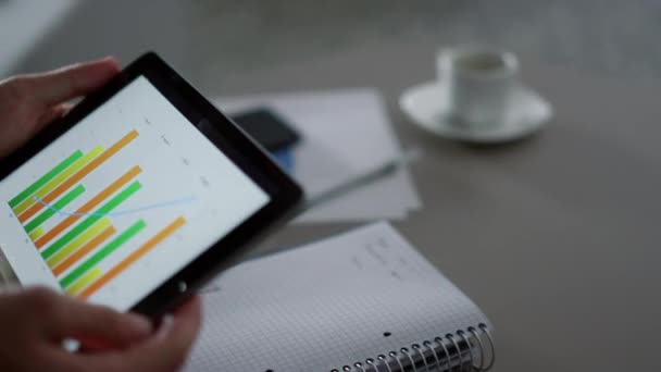 Manager schreiben Diagramm mit digitalem Tablet-Gerät im Home-Office-Café. — Stockvideo