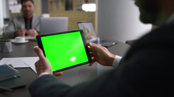 Medarbetare man rulla tablett grön skärm bläddra på webben på affärsmöte bord. — Stockvideo
