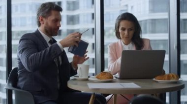 Başarılı şirket ekibi, pencere ofisinin dizüstü bilgisayarını kullanarak beyin fırtınası yapıyor..