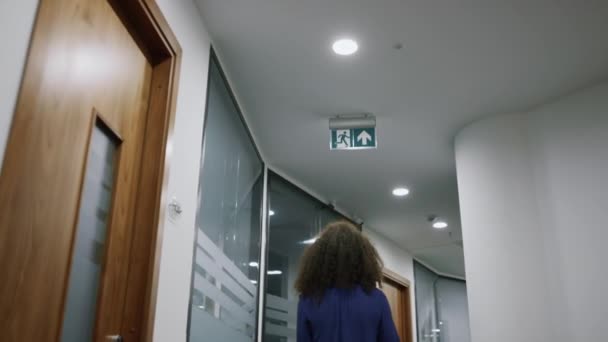 Afrikanisch-amerikanische Geschäftsfrau läuft selbstbewusst in Firmenbüro-Flur. — Stockvideo