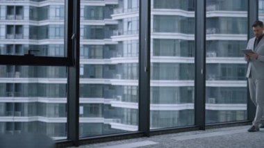 Ofis binasındaki kurumsal verileri araştırmak için tablet kullanan odaklı girişimci.