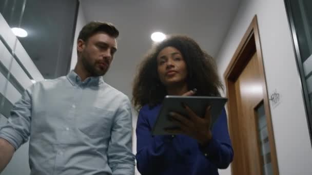 Менеджери команди робочого планшета обговорюють початок бізнесу в офісному коридорі . — стокове відео