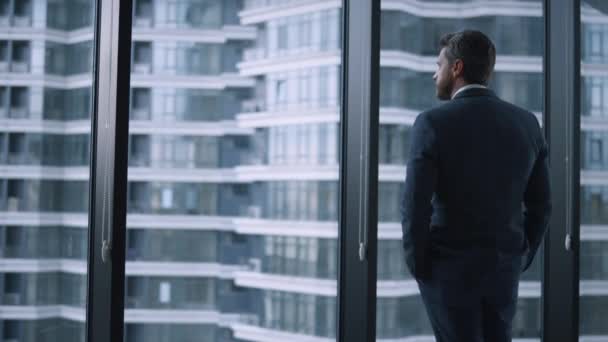 Successful businessman crossing hands looking window wall in corporate building. — Stock Video