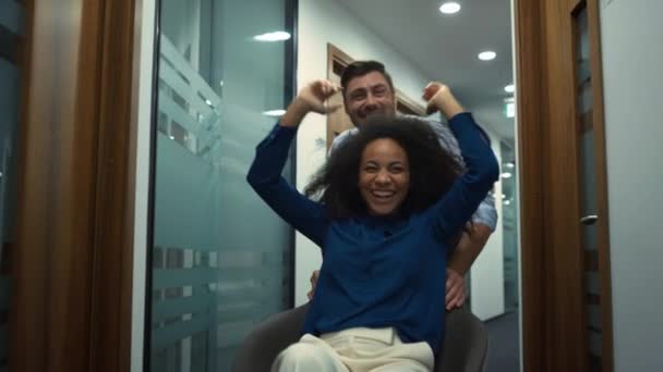 Équipe d'affaires multiethnique célébrant le succès en entreprise. Chaise de bureau course. — Video