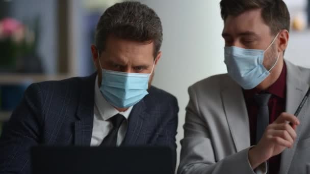 Diverzum vezetők csapat kutatás laptop viselni arc maszk a modern irodaházban. — Stock videók