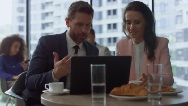 Focused business people discussing marketing using laptop computer in cafe. — Stock Video