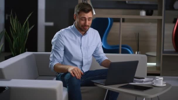 Ενθουσιασμένος επιχειρηματίας οδηγεί videoconference χρησιμοποιώντας φορητό υπολογιστή στο γραφείο της εταιρείας τεχνολογίας — Αρχείο Βίντεο