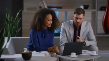 Kafede dizüstü bilgisayarı araştıran yaratıcı, çok ırklı bir çift.